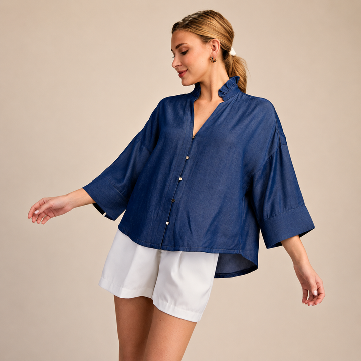Woman wearing a blue shirt and white shorts on a beige background