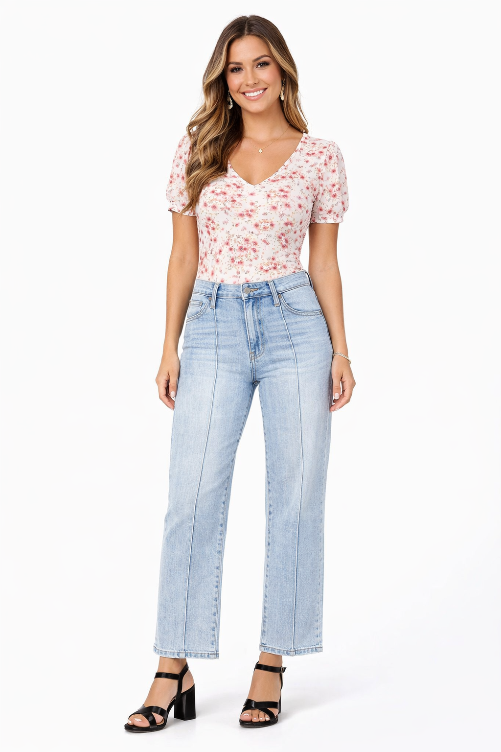 Woman wearing a floral top and light blue jeans on a white background