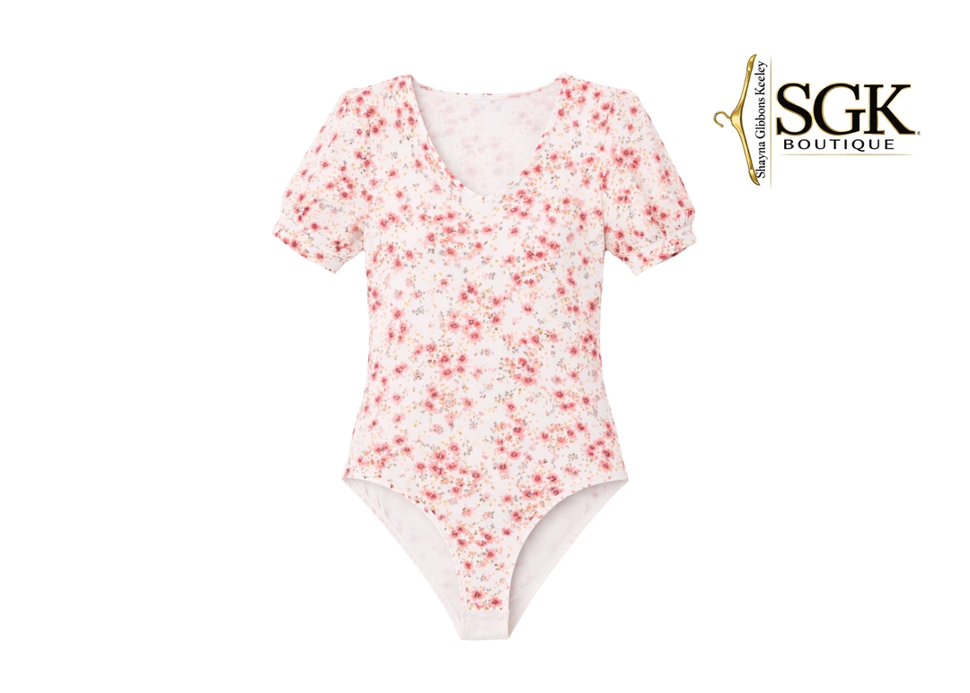 Floral-patterned bodysuit on a white background with SGK Boutique logo.