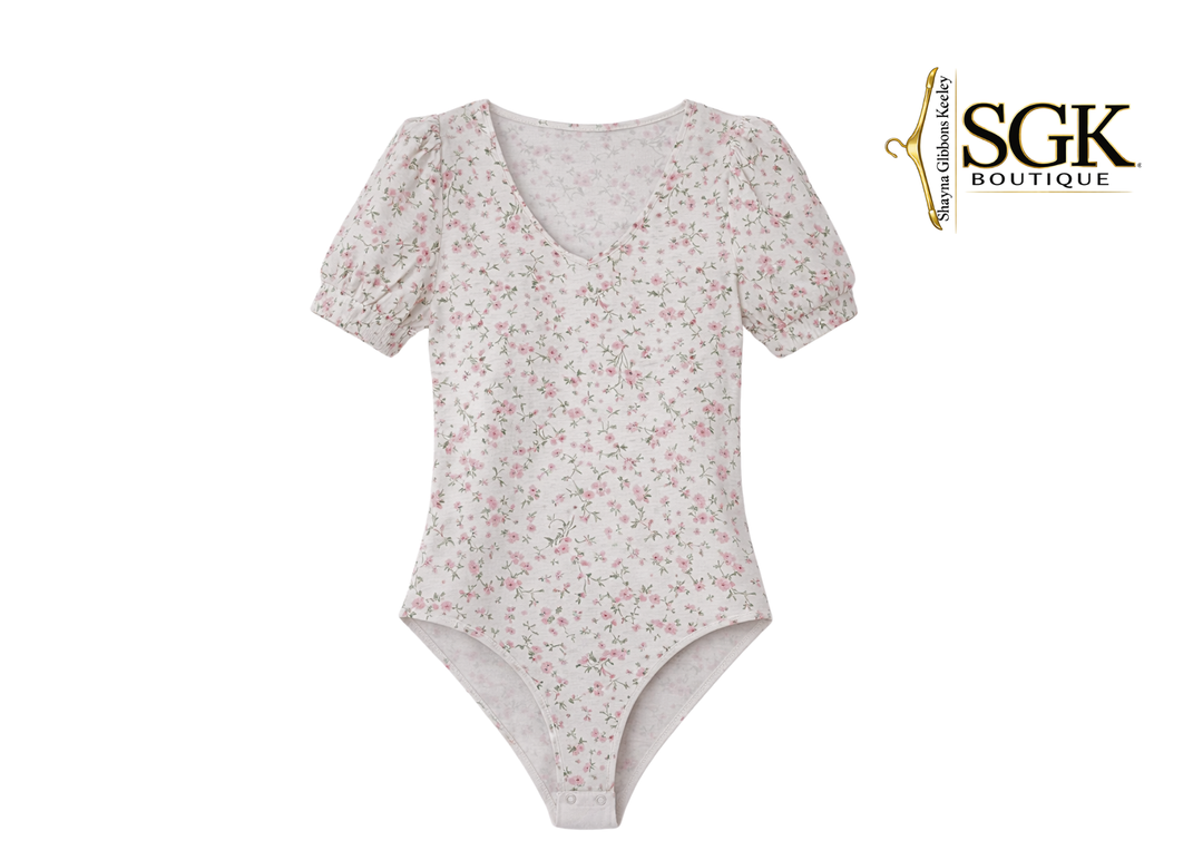 Floral-patterned bodysuit on a white background with SGK Boutique logo.