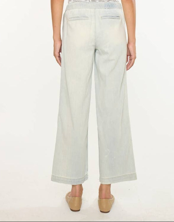 Woman wearing a light wash denim on a white background