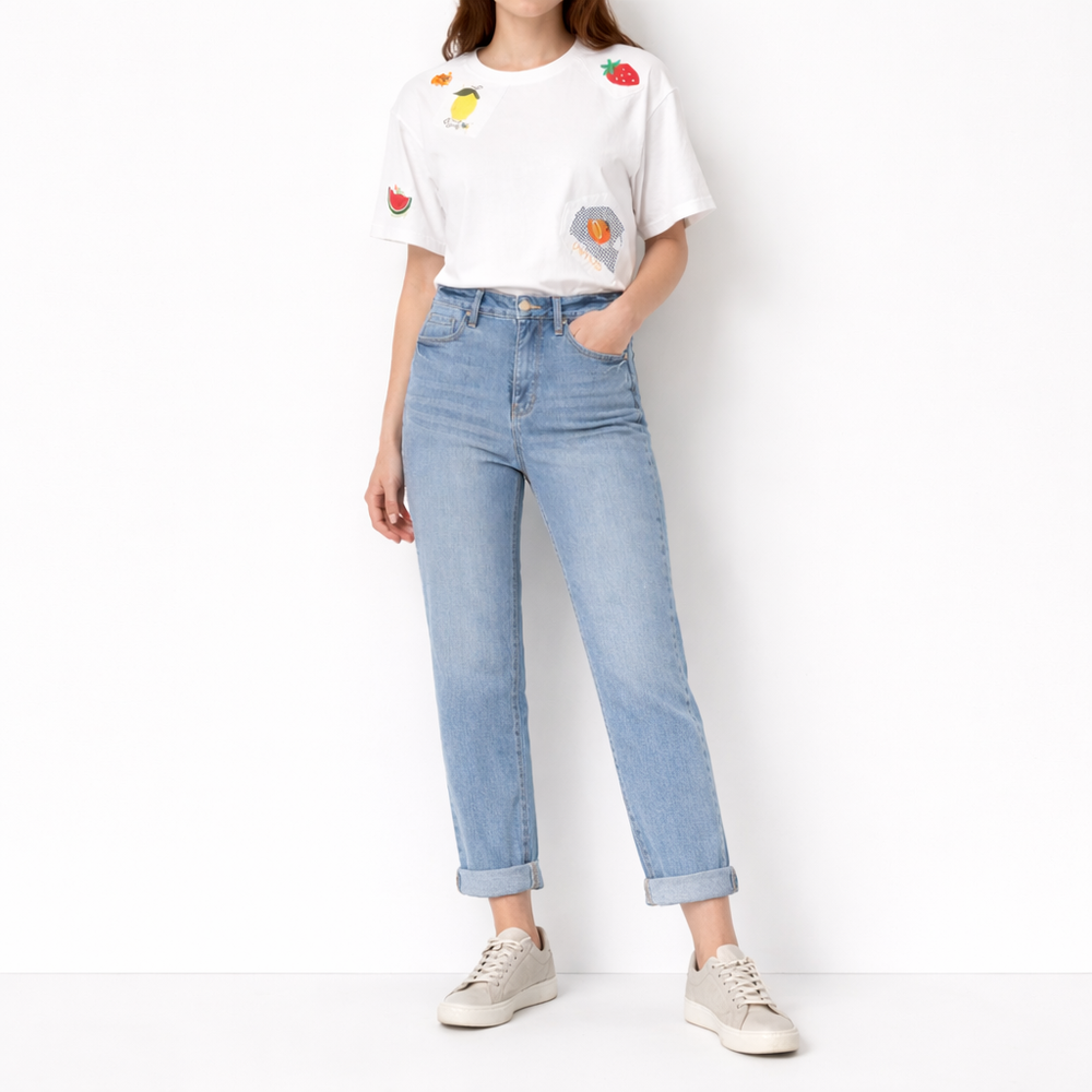 Person wearing a white t-shirt with colorful designs and light blue jeans on a white background