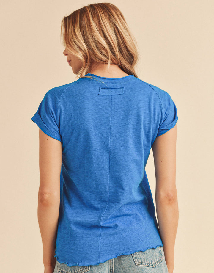 Woman wearing a blue t-shirt and denim shorts on a beige background