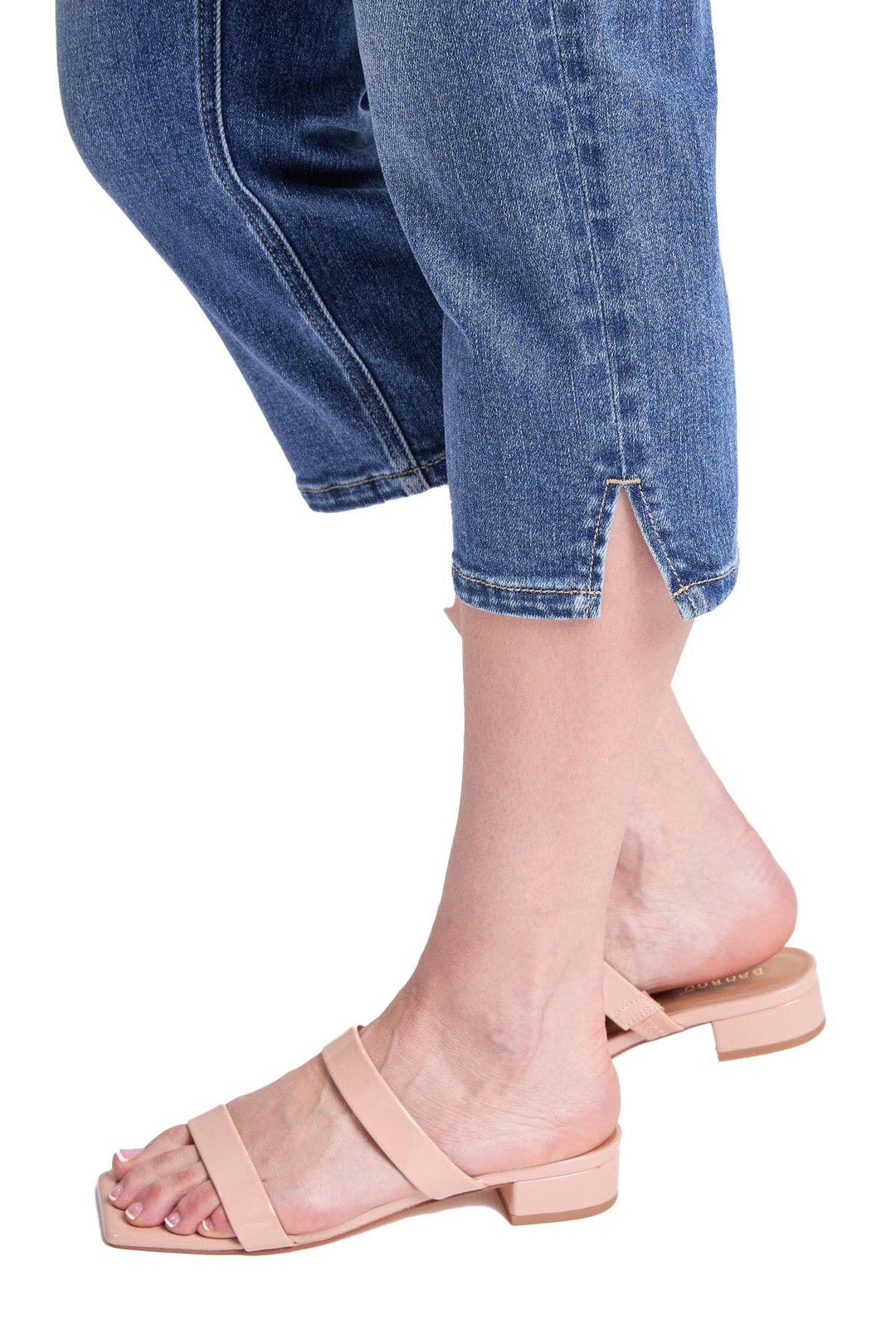 Person wearing light pink sandals with a white background