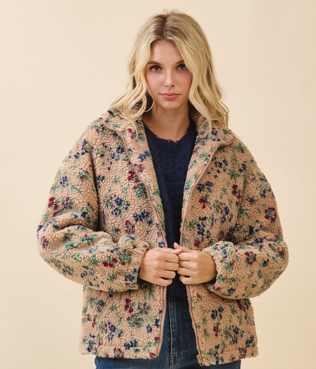 Woman wearing a floral patterned jacket on a beige background