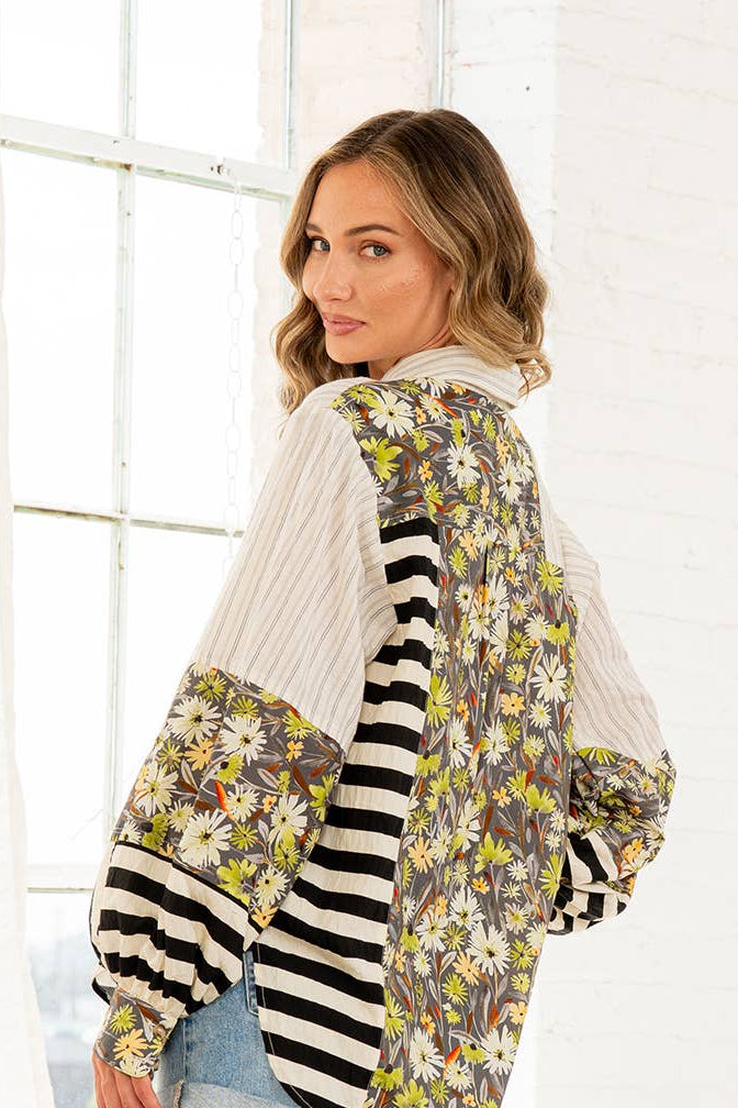 Woman wearing a floral and striped cardigan in a bright room.