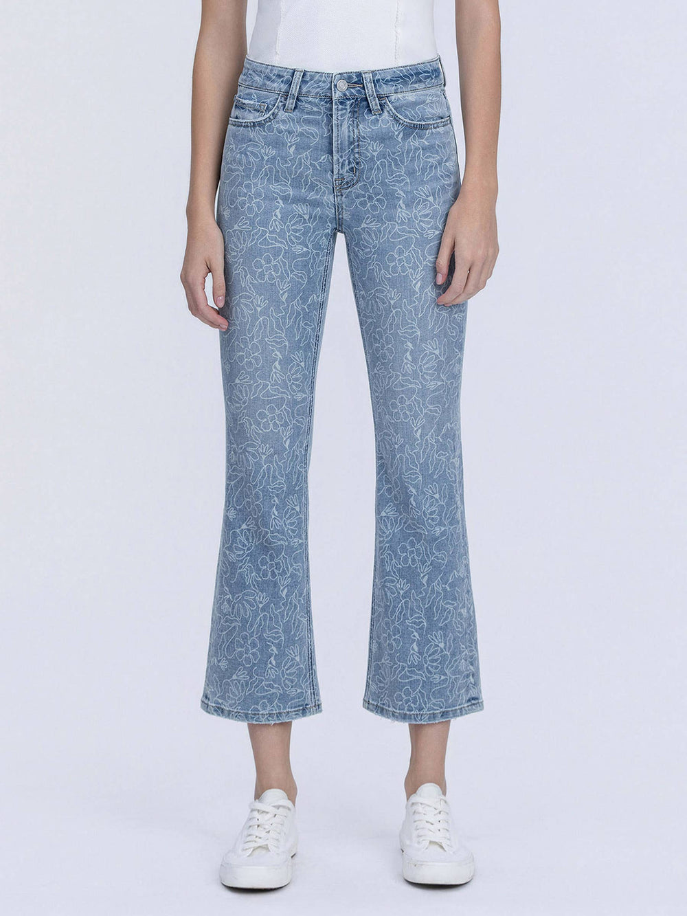 Person wearing light blue acid-wash jeans on a white background