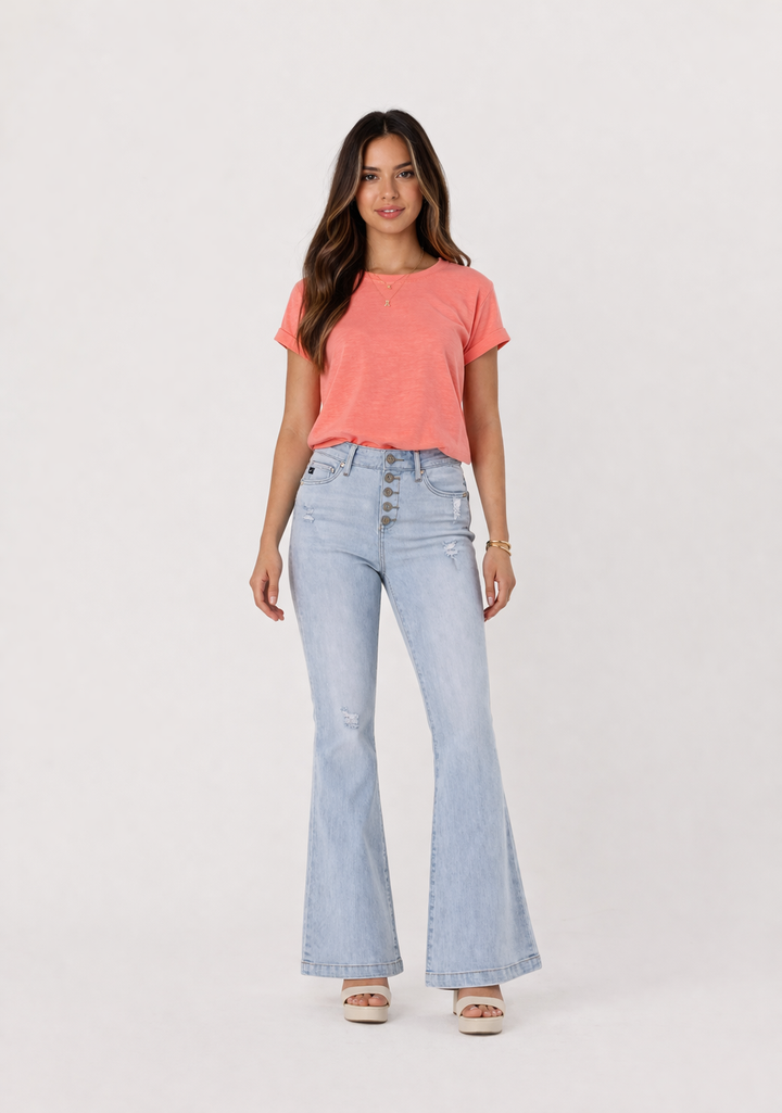 Woman wearing a coral t-shirt and light blue flared jeans on a white background