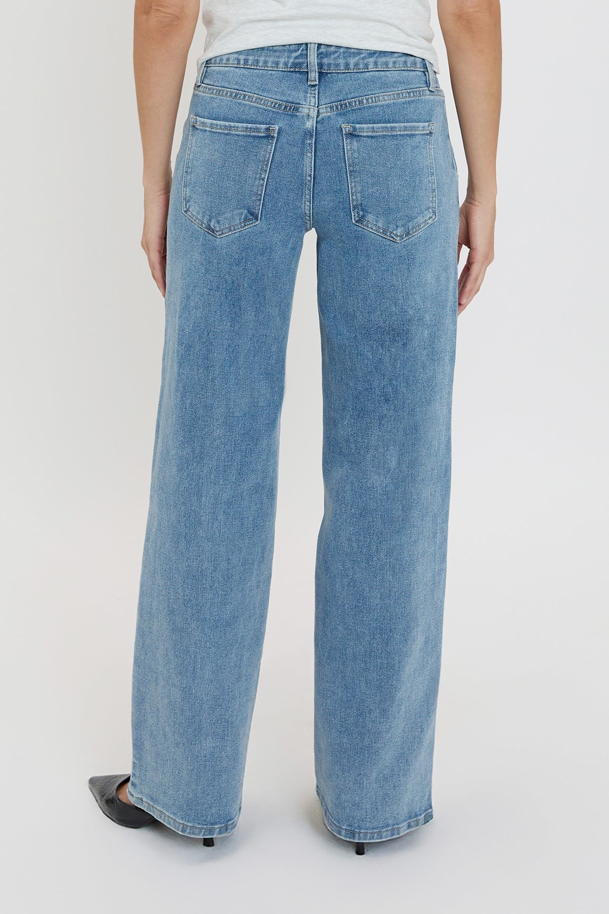 Blue jeans worn by a person on a white background