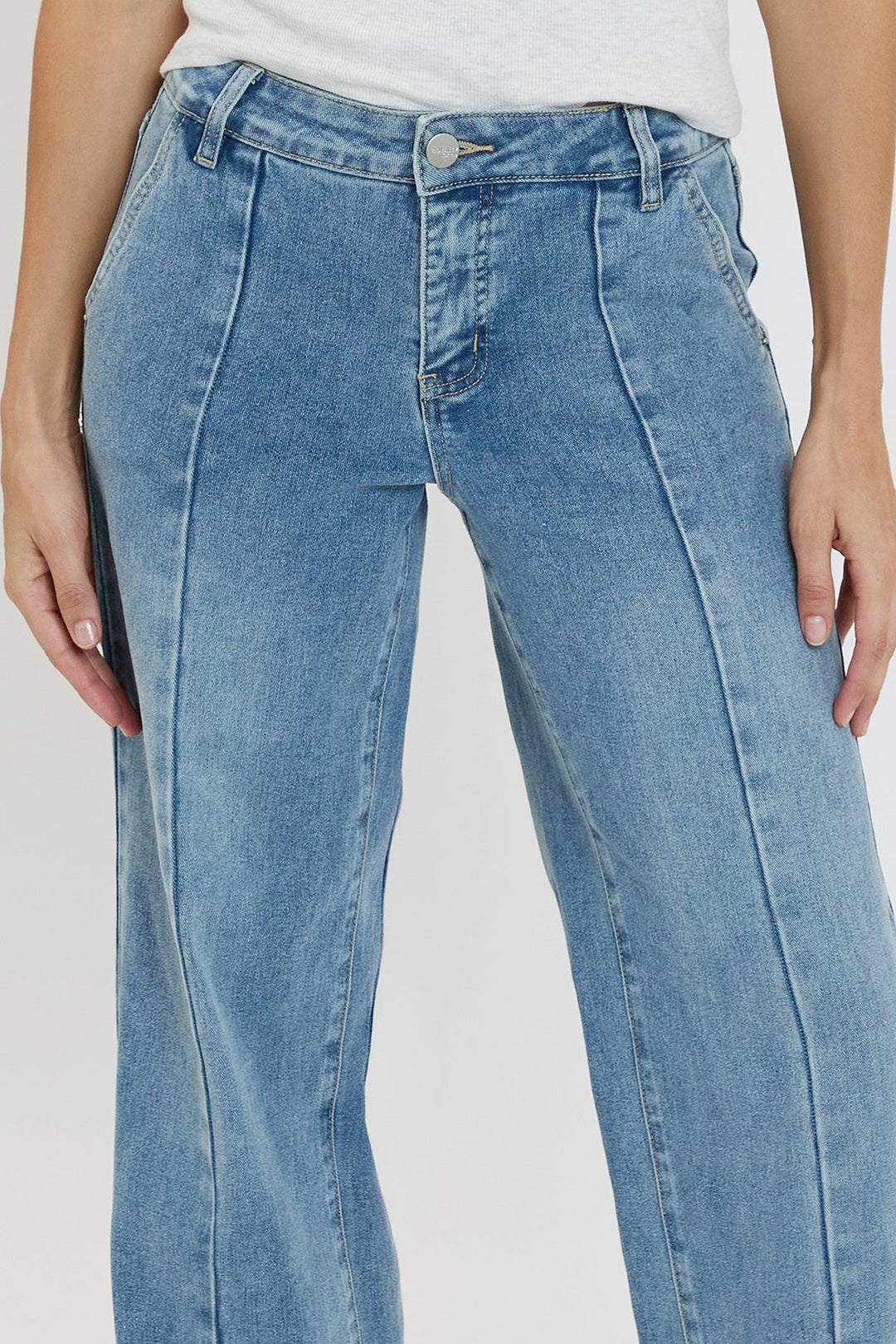 Light blue jeans worn by a person on a plain background