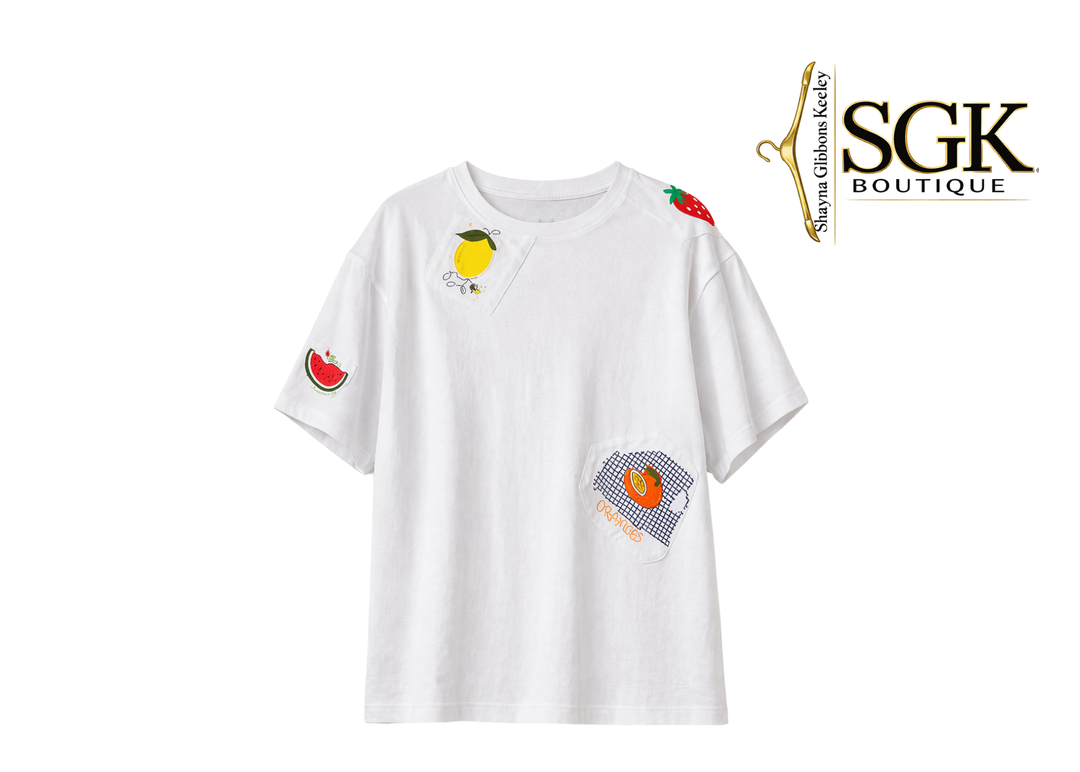 White t-shirt with colorful fruit patches on a white background, featuring the SGK Boutique logo.