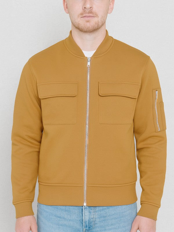 Man wearing a ginger bomber jacket with a plain background