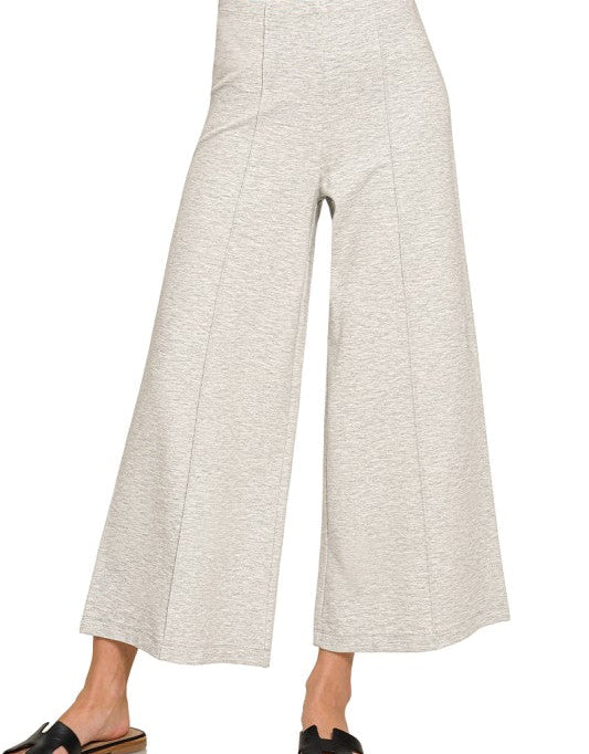 Light gray wide-leg pants worn by a person on a white background
