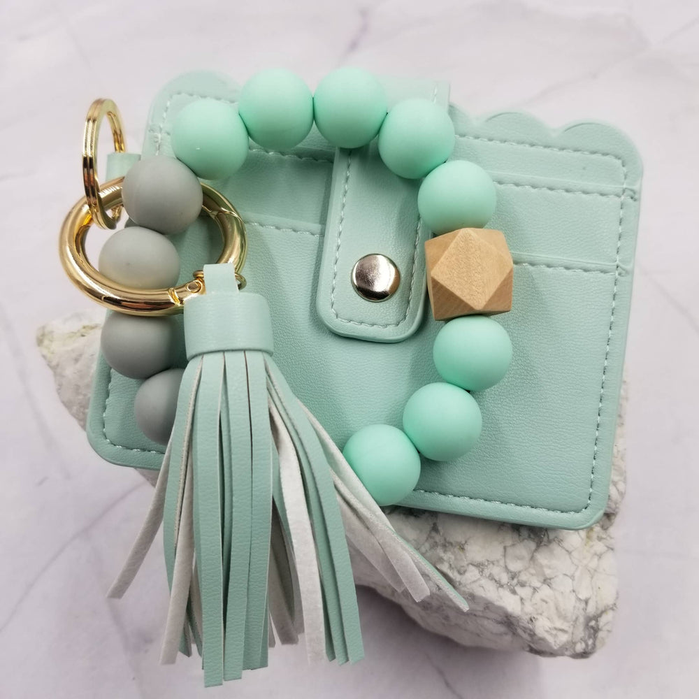 Mint green keychain with beads and tassel on a light background