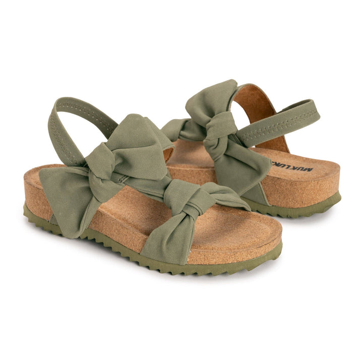 Green sandals with bow details on a white background