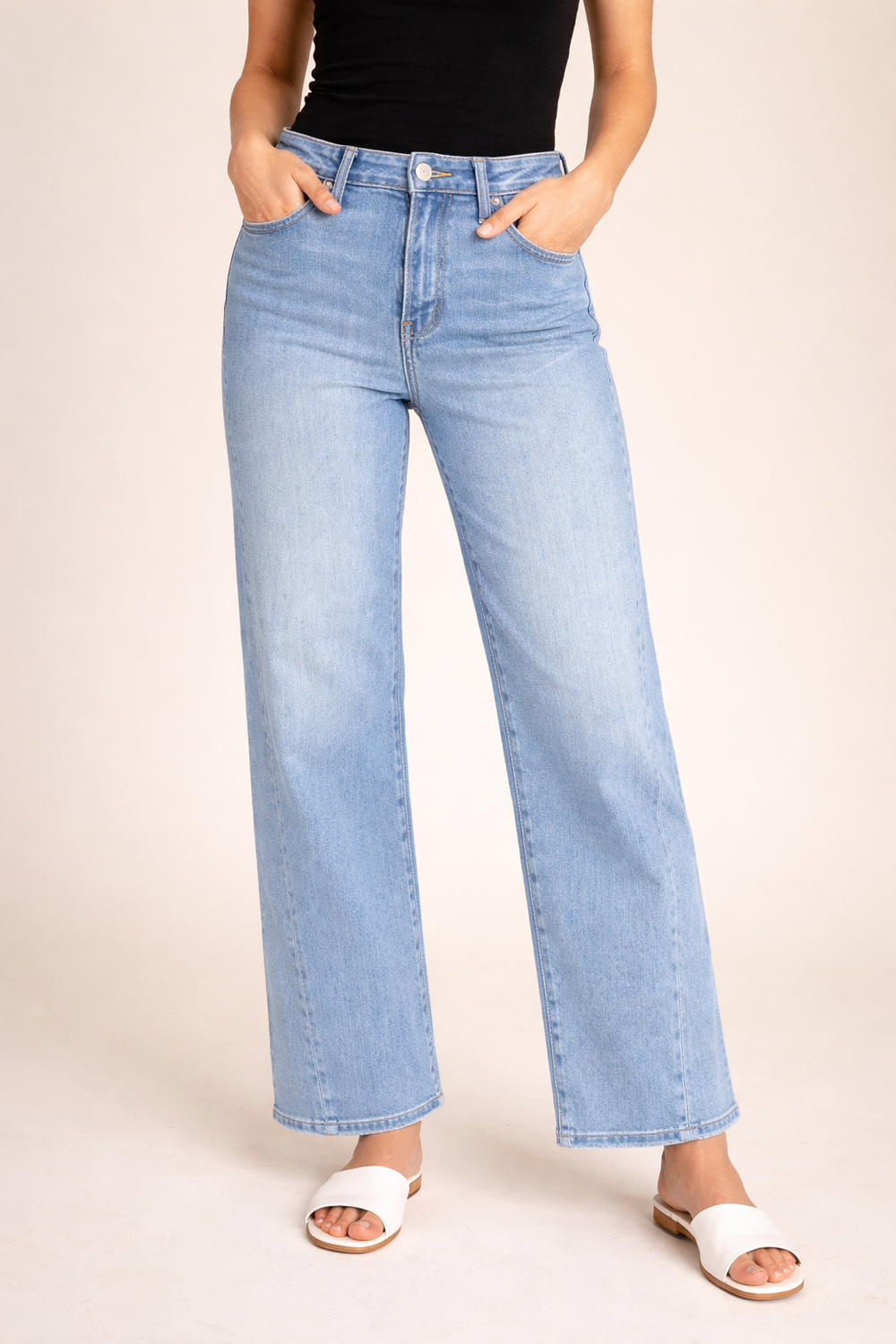 Light blue jeans worn by a person on a beige background