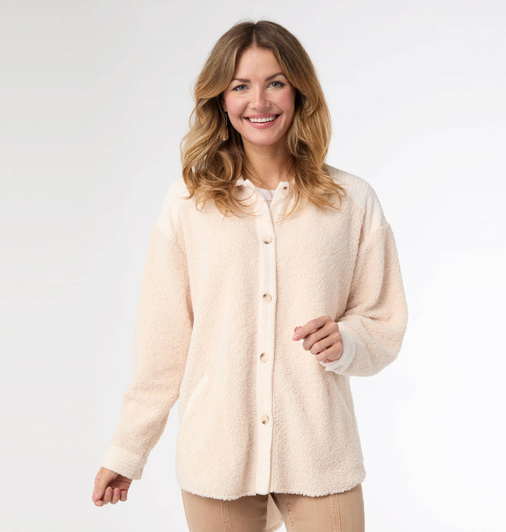 Woman wearing a cream-colored fleece shirt on a white background