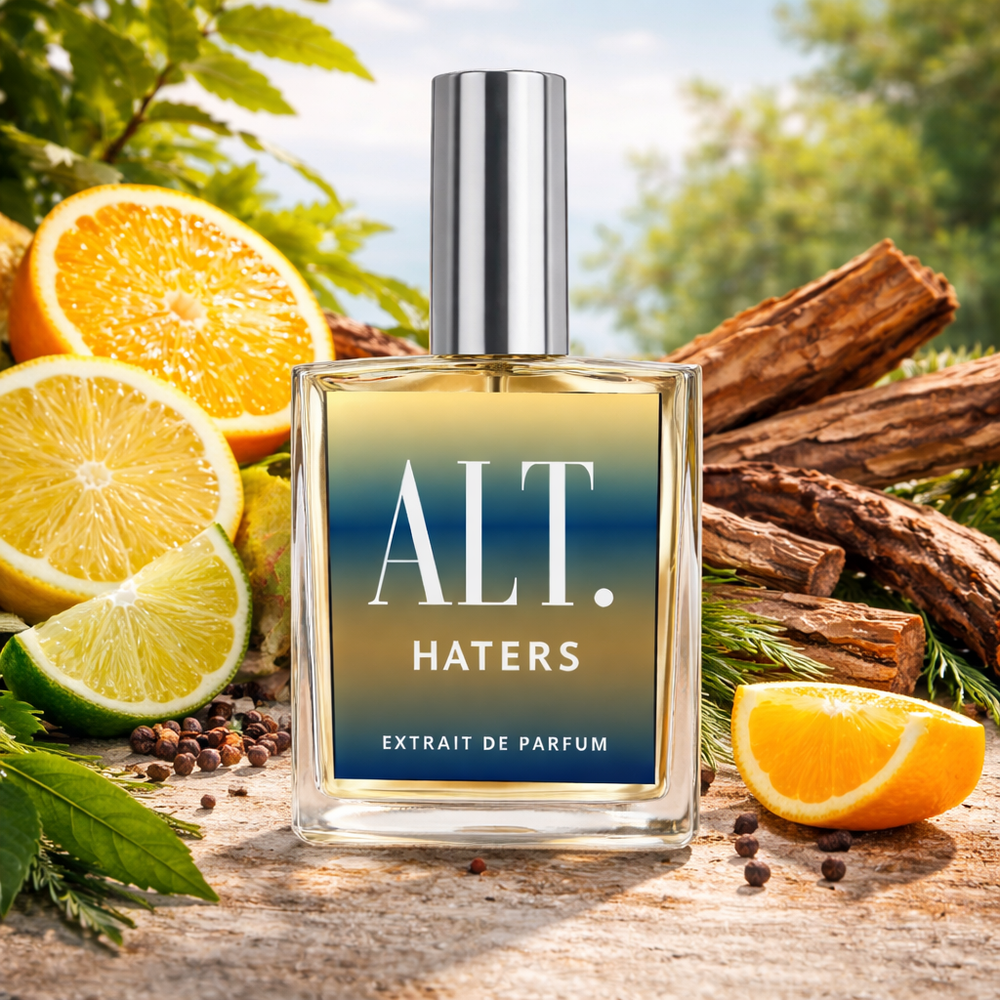 Perfume bottle labeled 'ALT. HATERS' with citrus fruits and cinnamon sticks on a wooden surface.