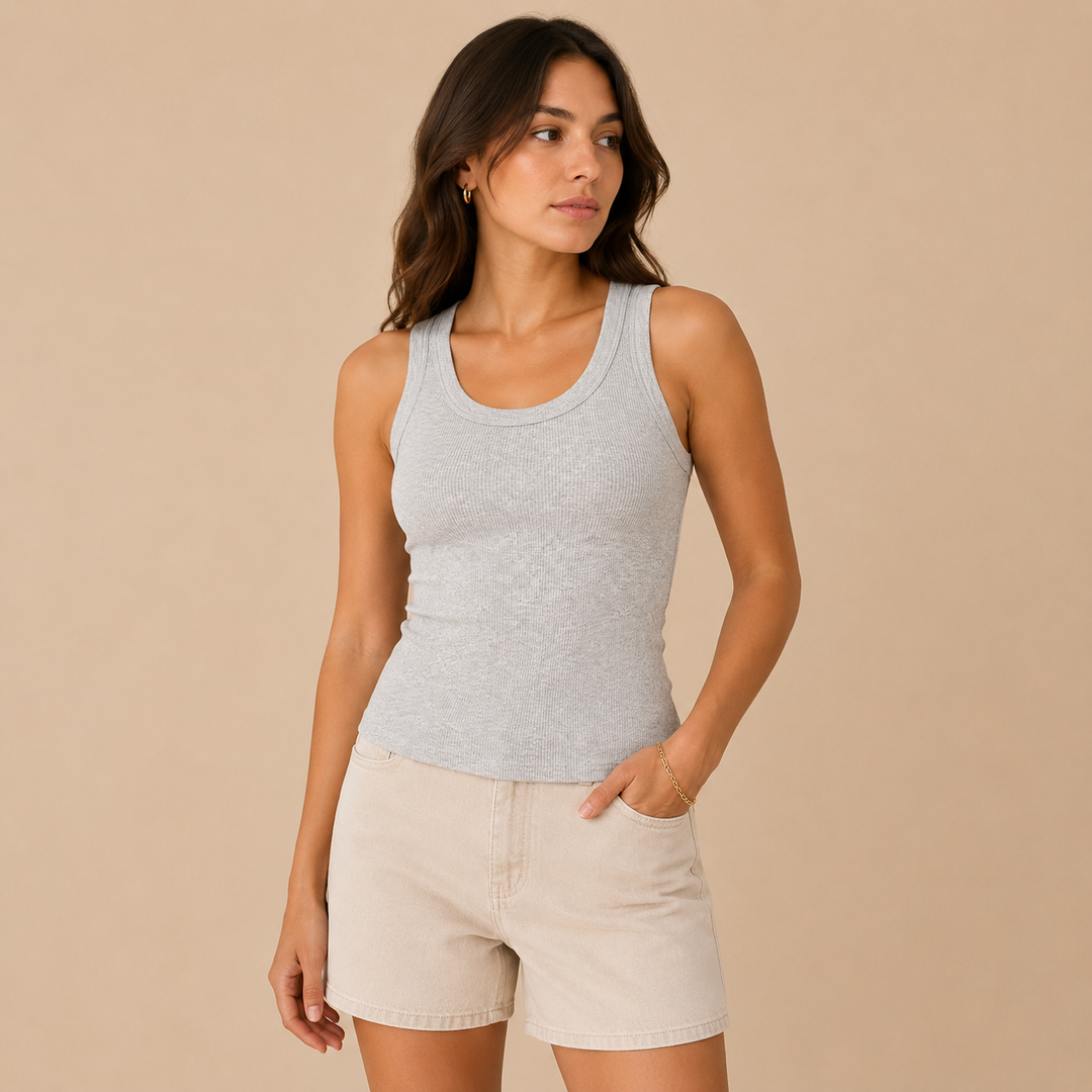 Woman wearing a gray tank top and beige shorts against a beige background