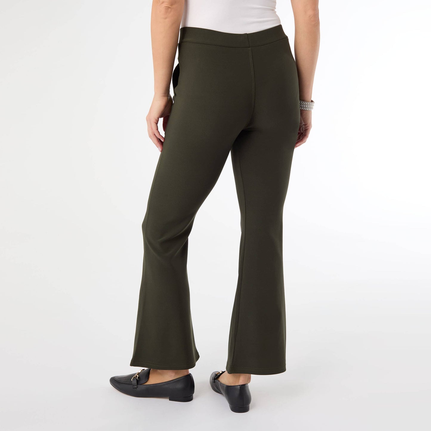 Person wearing olive green flared pants on a white background