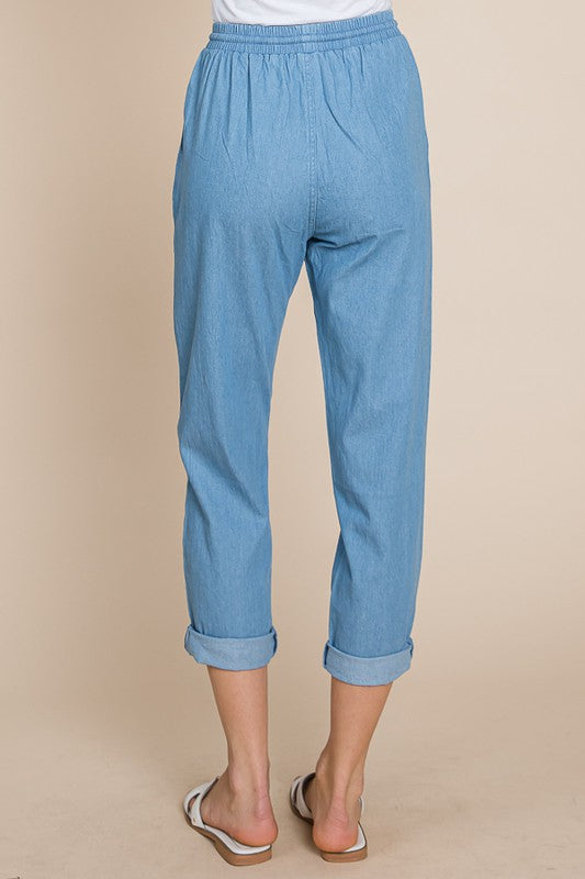 Light blue pants worn by a person on a beige background