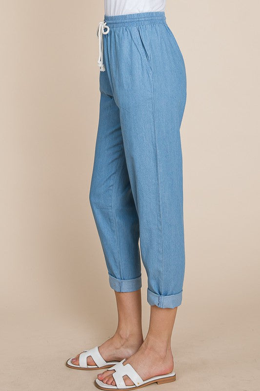 Light blue pants worn by a person on a beige background