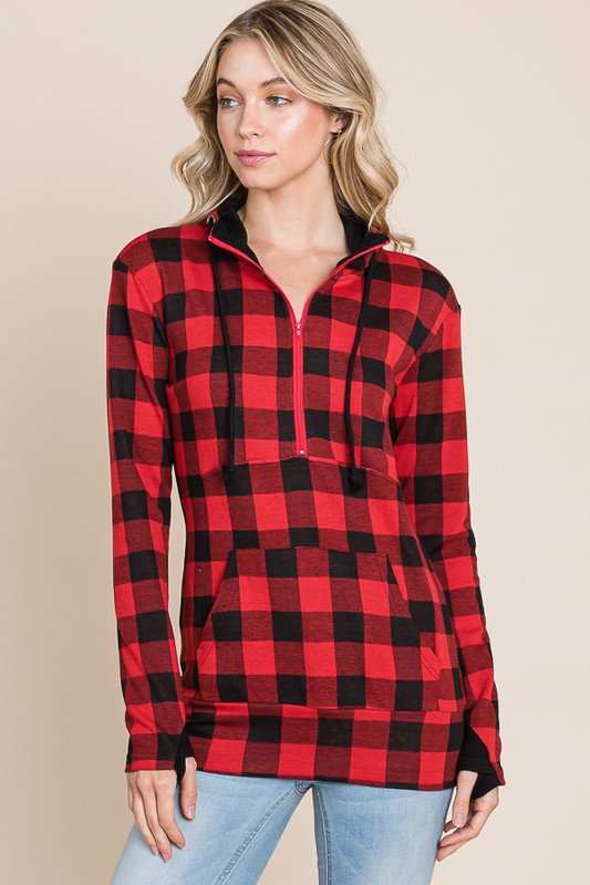 Woman wearing a red and black plaid shirt against a beige background