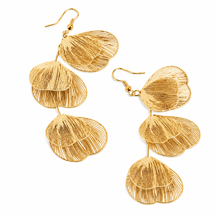 Gold leaf-like earrings on a white background