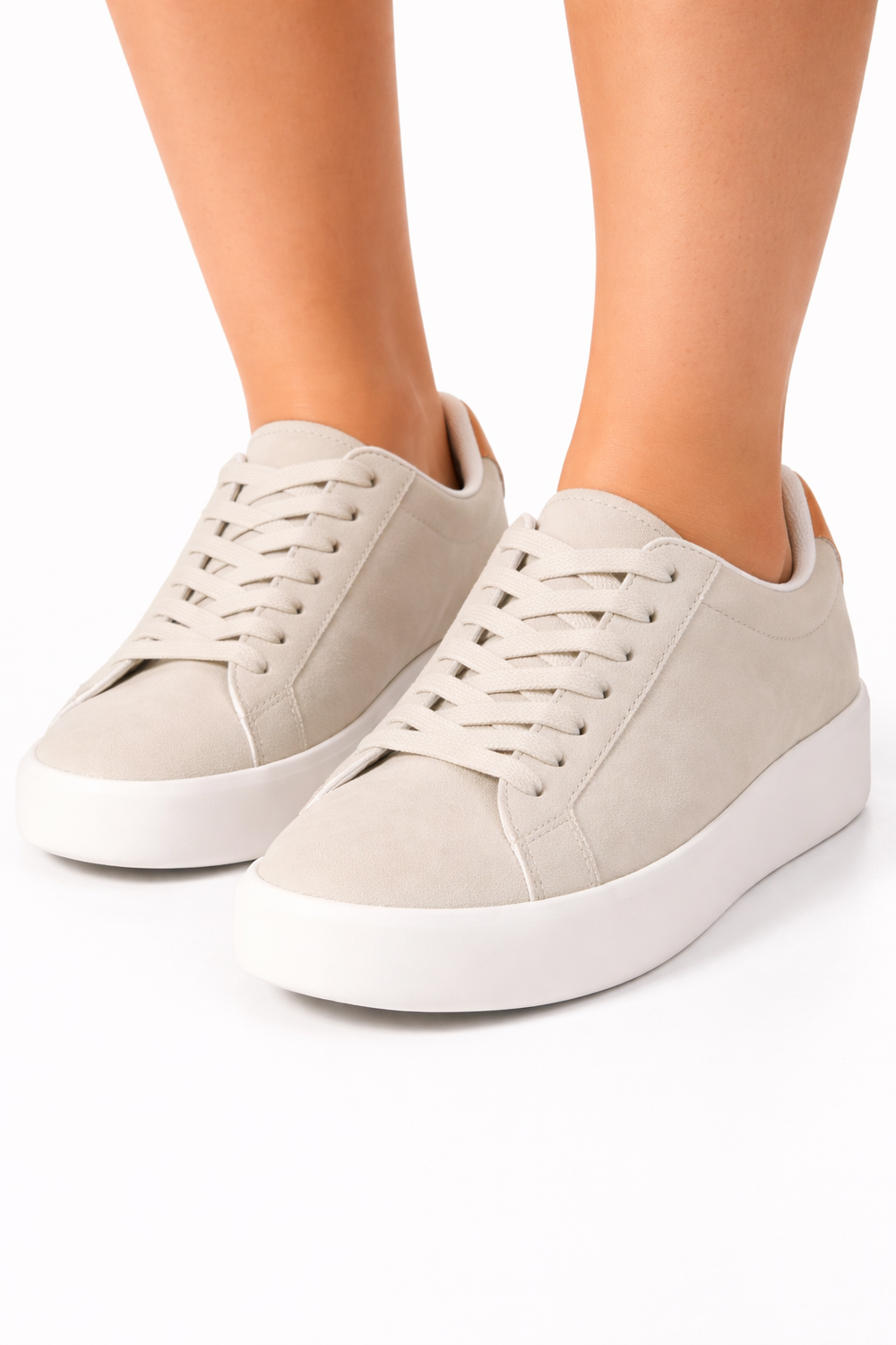 Beige sneakers with white soles on a white background