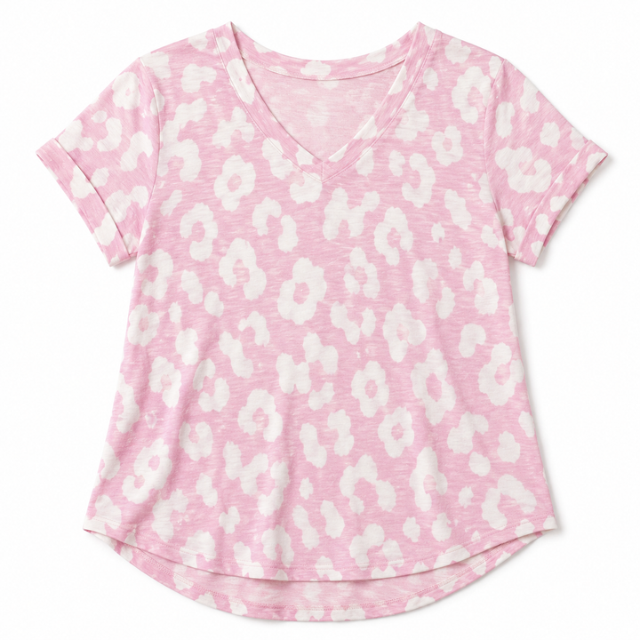 A pink short-sleeve V-neck t-shirt with a white abstract floral or leopard-like spot pattern, shown flat against a white background.