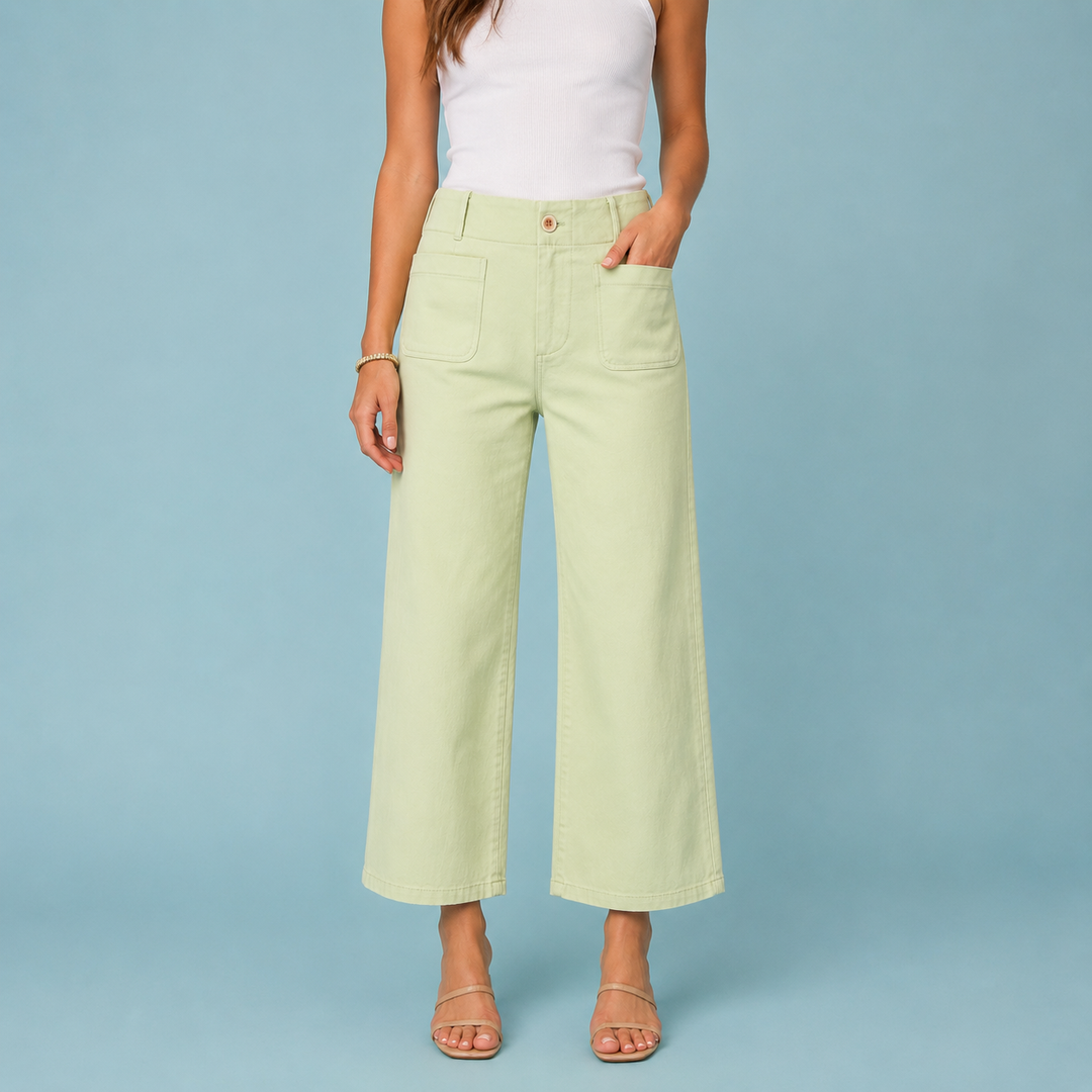 Person wearing light green pants and a white top on a blue background