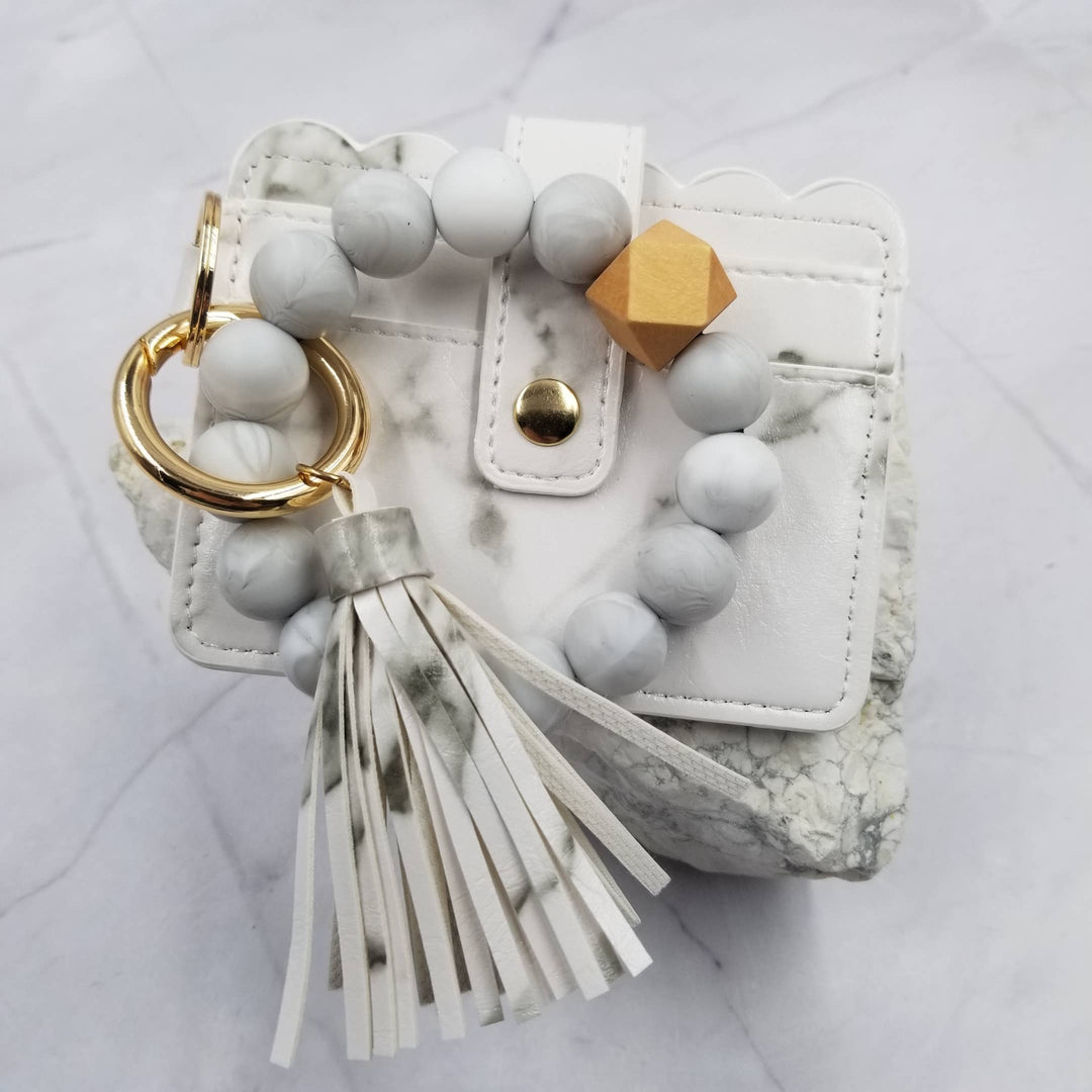 Marble-textured keychain with beads and tassel on a white background