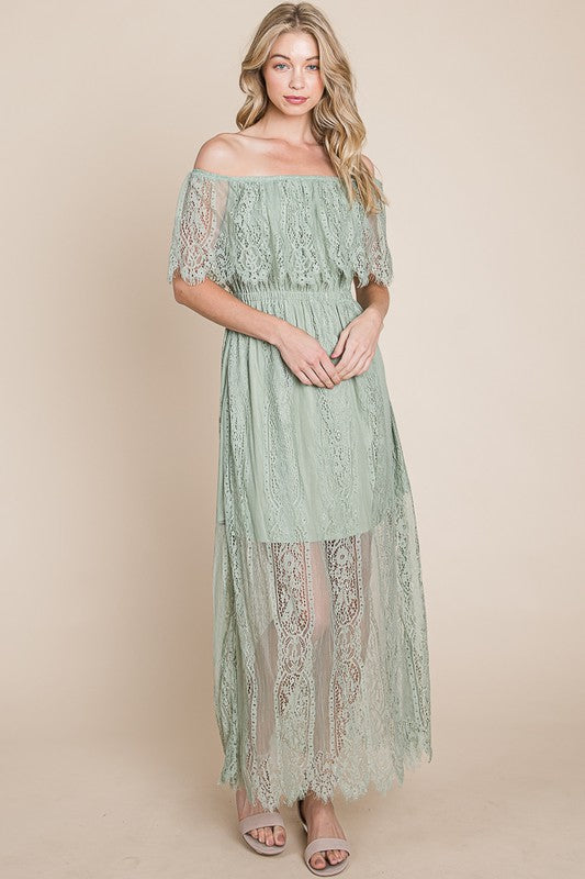 Woman wearing a light green lace dress against a beige background