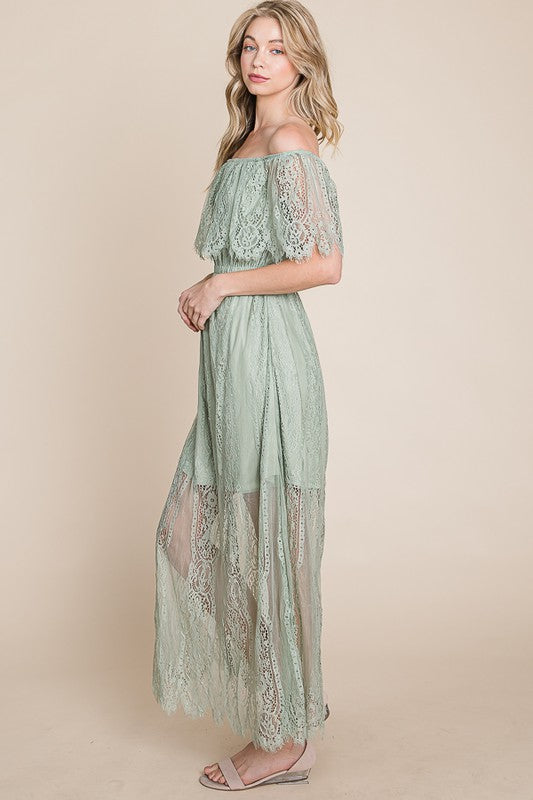 Woman wearing a green lace dress against a beige background