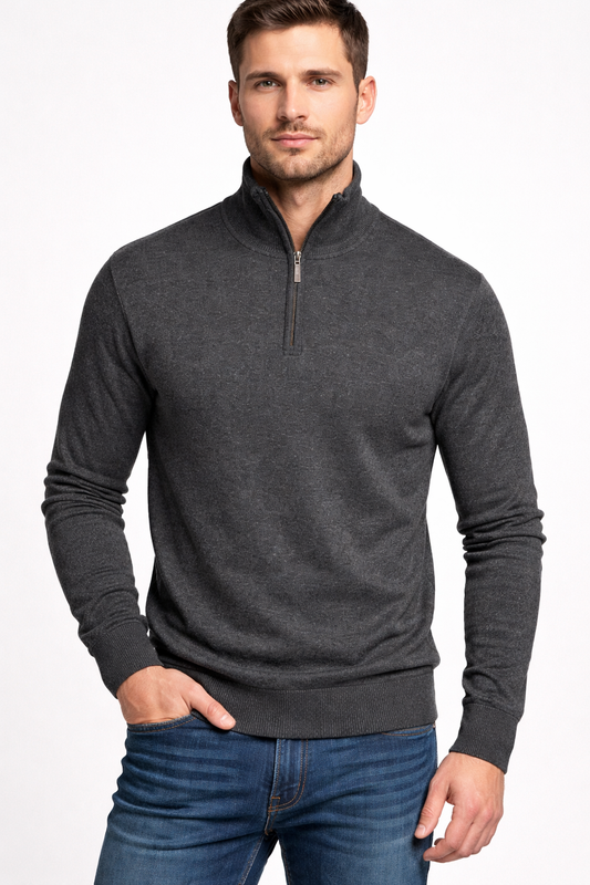 Man wearing a dark gray quarter-zip sweater and blue jeans on a white background