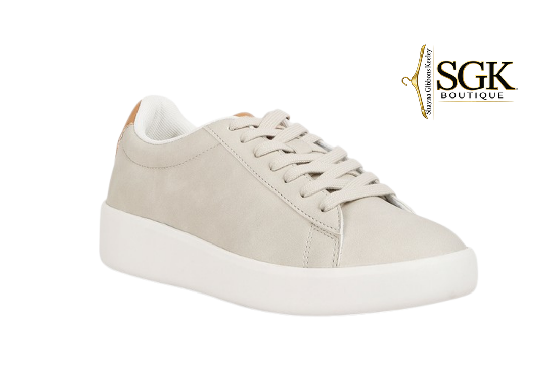 Beige sneaker with white sole on a white background, featuring SGK Boutique logo.