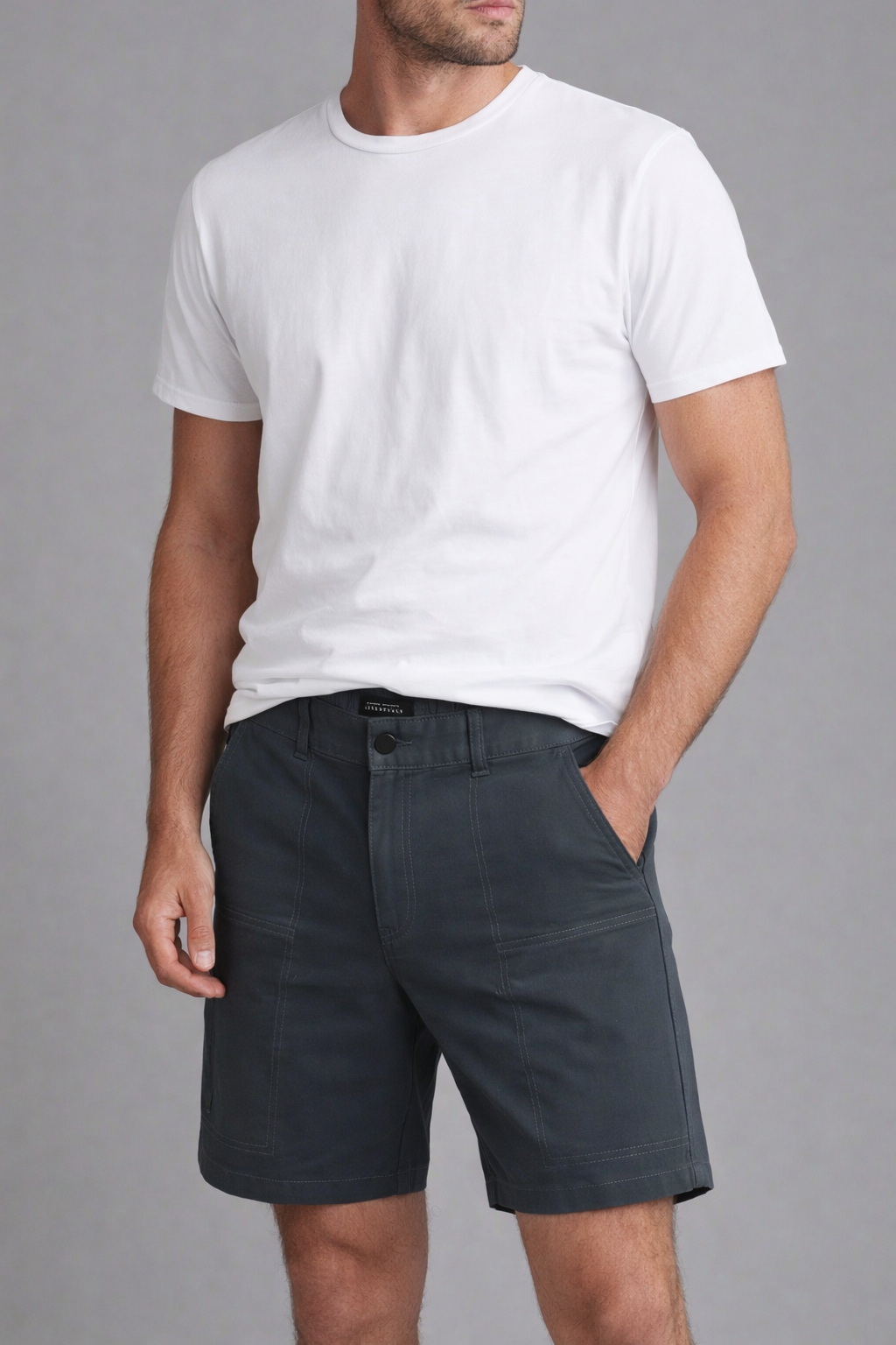 Man wearing a white t-shirt and navy on a gray background