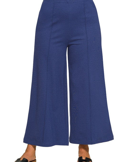 Navy blue wide-leg pants worn by a person on a white background
