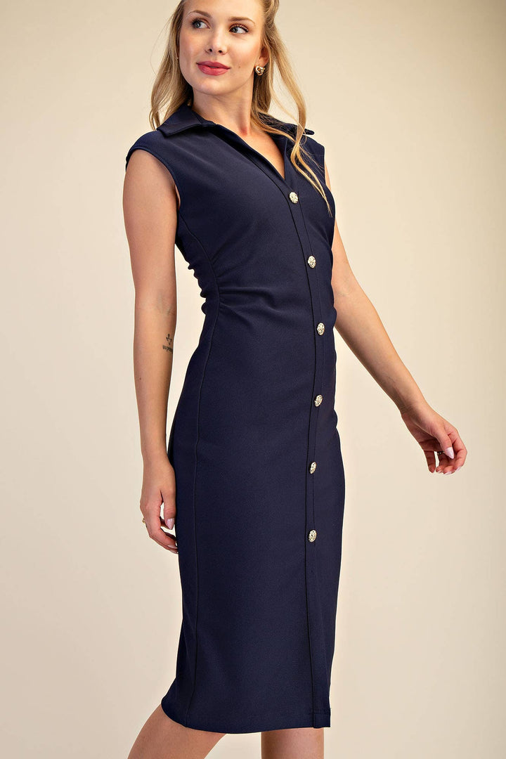 Woman wearing a navy dress with buttons on a beige background