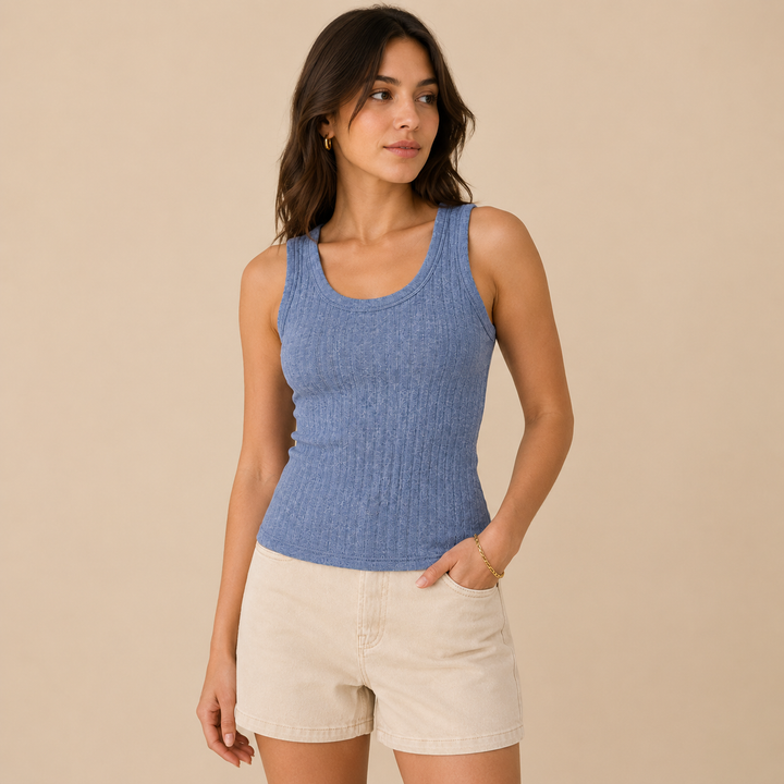 Woman wearing a blue tank top and beige shorts against a beige background