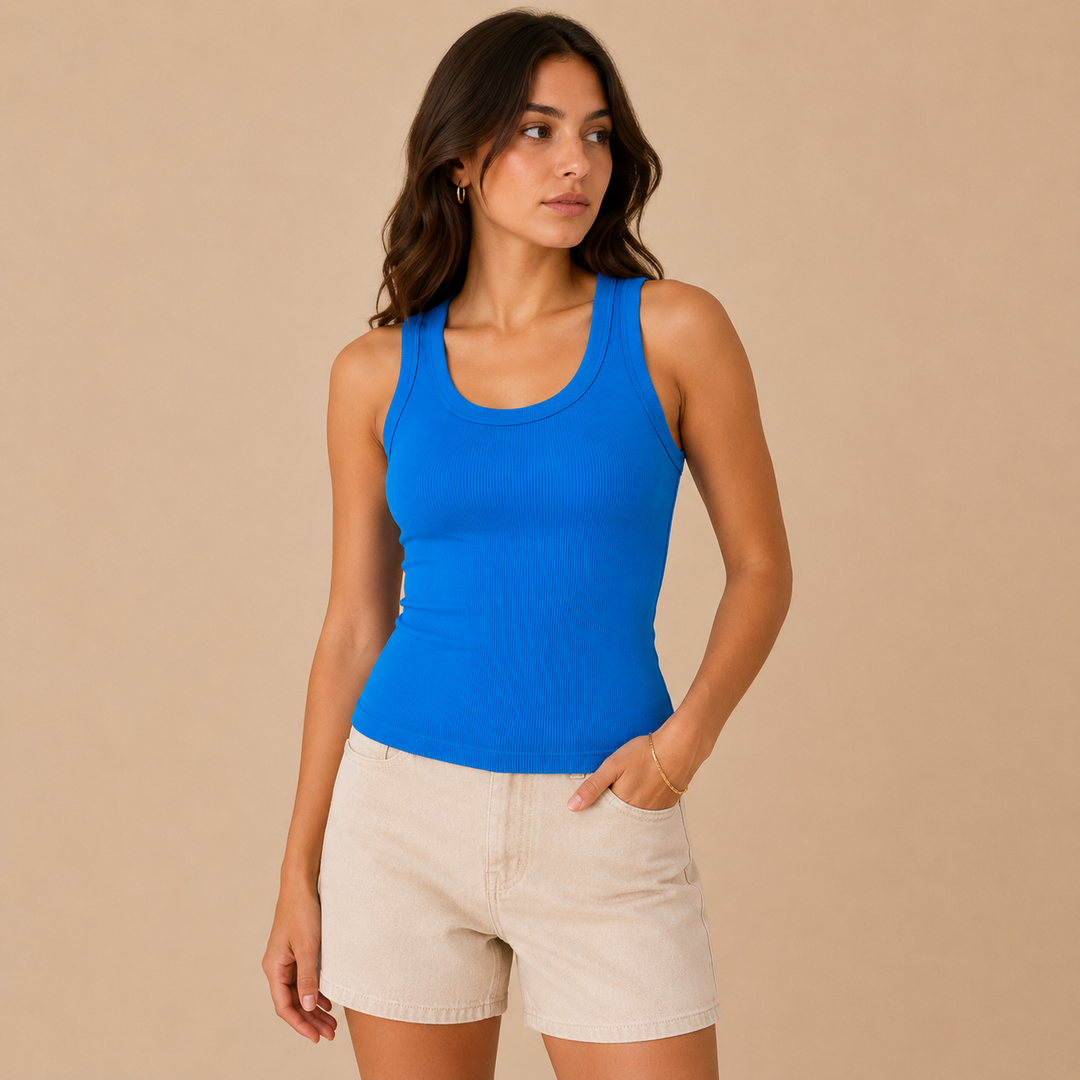 Woman wearing a blue tank top and beige shorts against a beige background