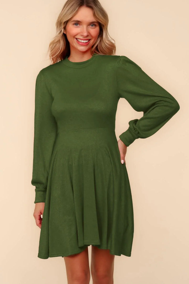 Woman wearing a green dress against a beige background