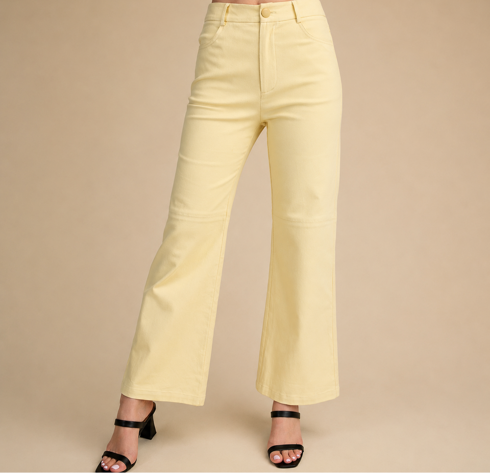 Light yellow wide-leg pants worn by a person on a beige background
