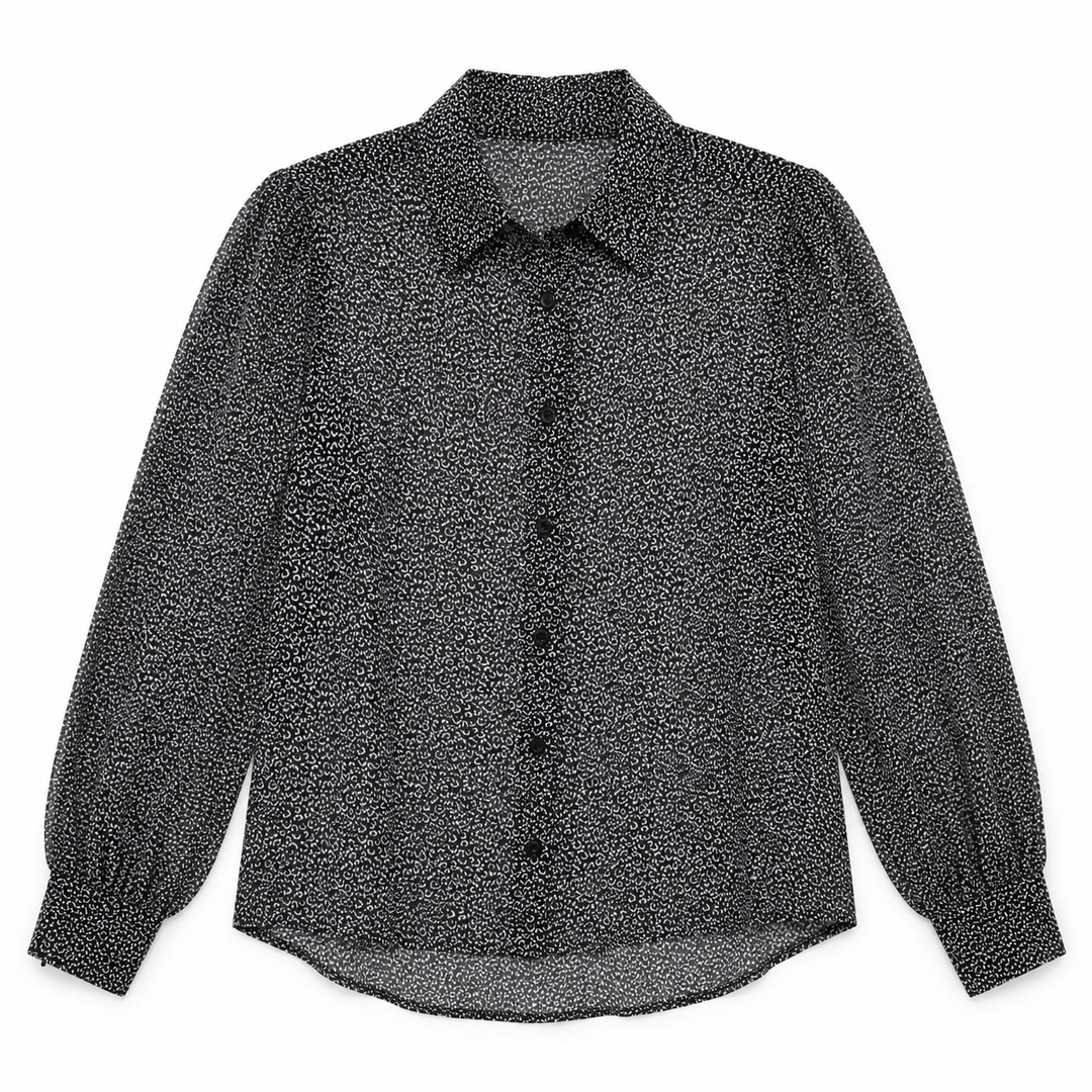 A long-sleeve button-up blouse with a textured, speckled black and white pattern, featuring a pointed collar and gathered cuffs, shown flat on a white background.