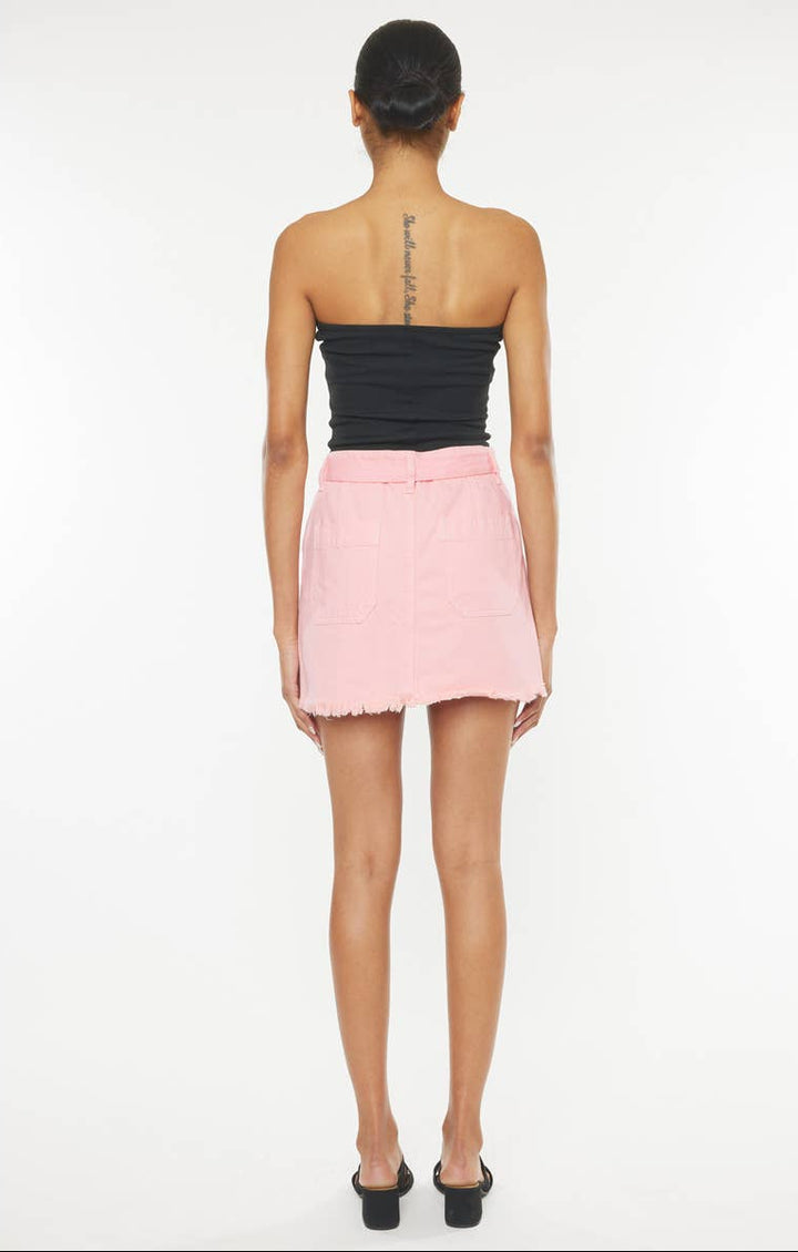 Woman wearing a black strapless top and pink skirt on a white background