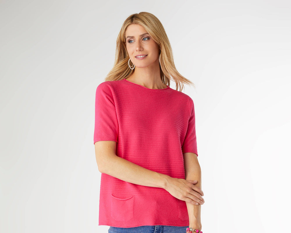Woman wearing a pink top and blue jeans on a white background