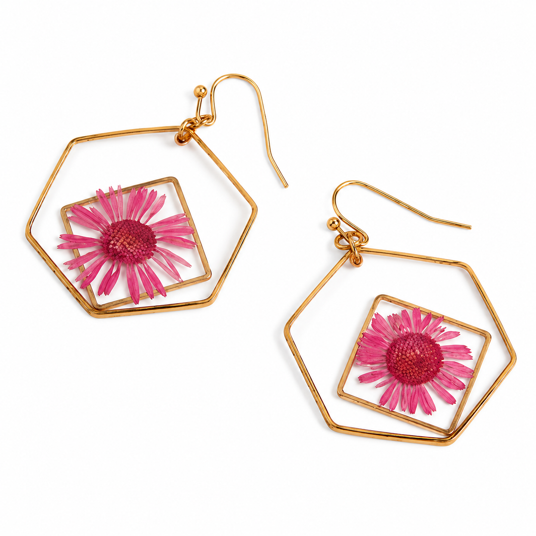 Gold hoop earrings with pink floral elements on a white background