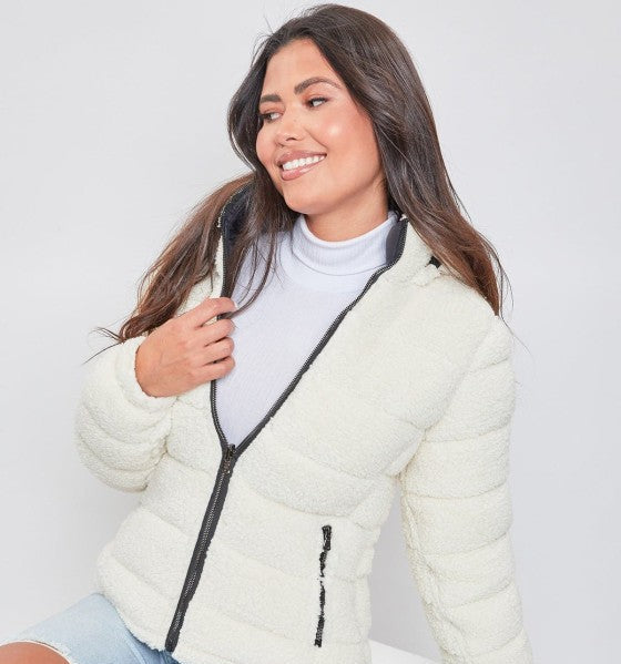 Woman wearing a white puffer jacket with a gray zipper on a white background