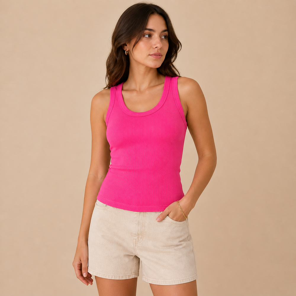 Woman wearing a bright pink tank top and beige shorts against a beige background