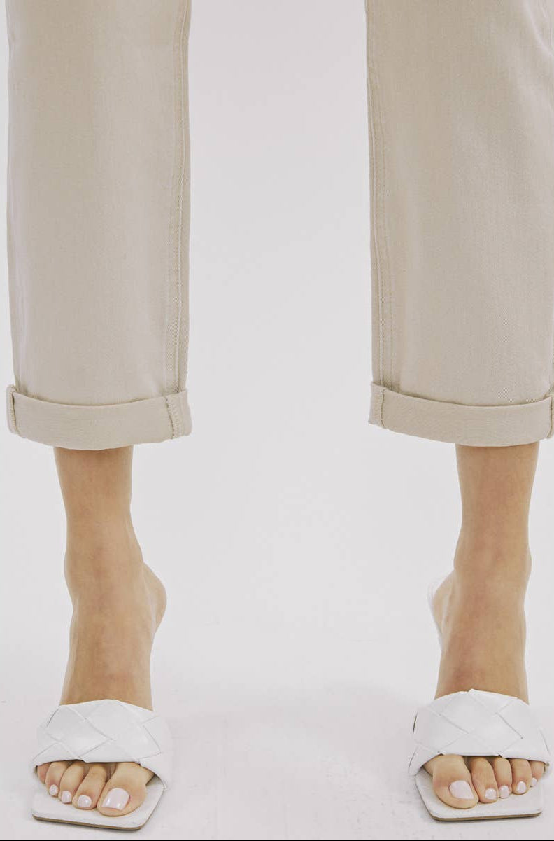 White sandals worn with beige pants on a white background